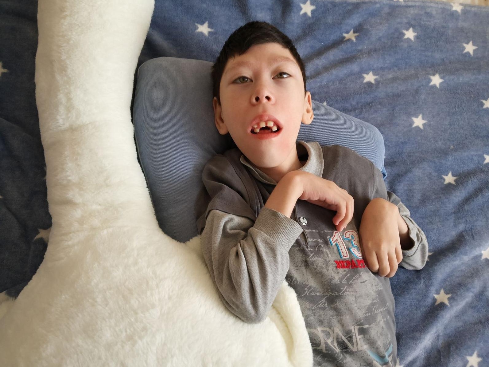 Since childhood, Arseny has been almost paralyzed: he needs stabilizing pillows to support his body.